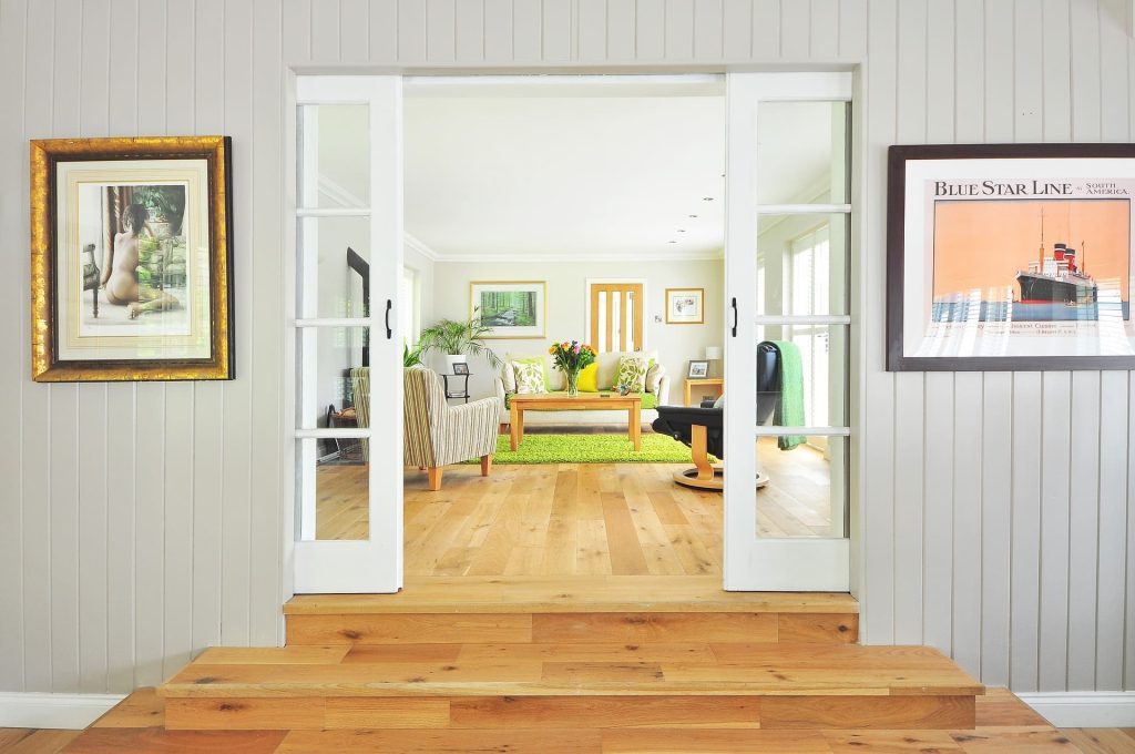 Adding value to your home | A living room seen through white sliding doors, with armchairs, a sofa and a coffee table