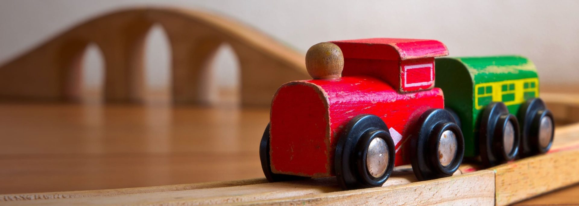 Bridging Loans Hero Image | An image of a red toy wooden train with a wooden track bridge in the background