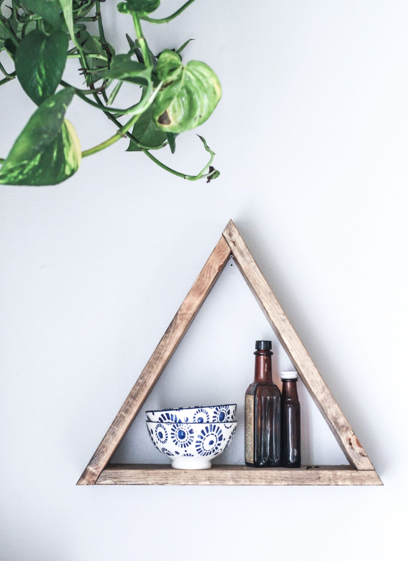 Buy-to-Let Portfolio Landlords | A wooden, triangle wall shelf with bowls and salad dressings with a plant in the top left and corner