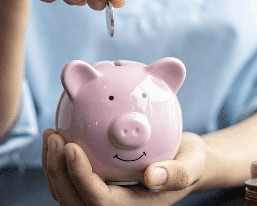 Low Income Mortgage Widget | A person holding a pink piggy bank in their palm, adding coins into the bank