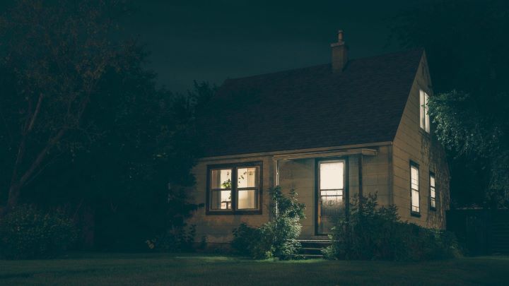 Household insurance | A small house with the lights on in the dark