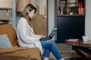 Getting out of a fixed rate early | Woman sitting on her sofa with a laptop