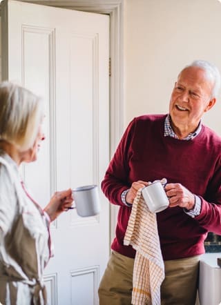 Lifetime Mortgages | Elderly couple doing the dishes smiling