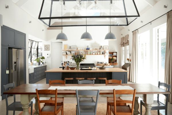 Renovating a house | Open plan kitchen with hanging lights, a large dining table, double fridge and kitchen island