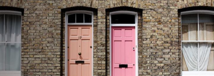 Tenant Fees Act 2019 | Pink and peach front doors set back to back in light brick terraced houses