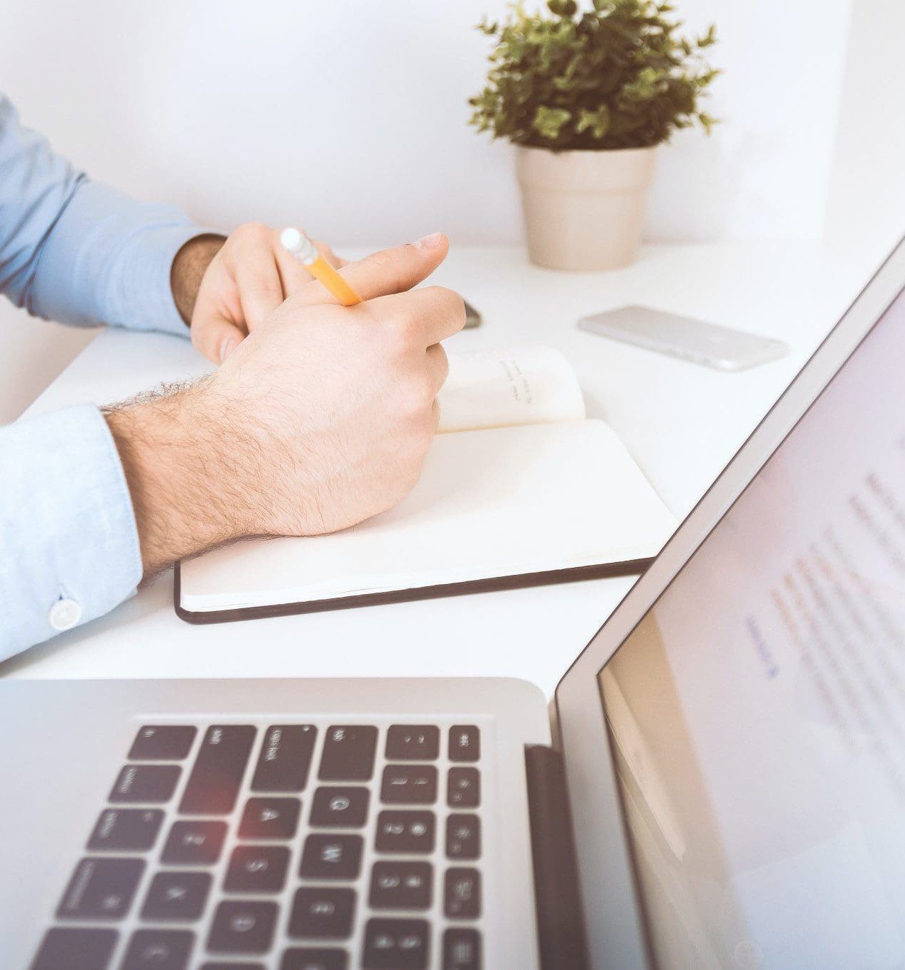 What stops you getting a mortgage | Man taking notes from a laptop screen on his desk