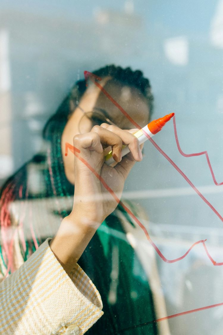 A woman writing on a glass board