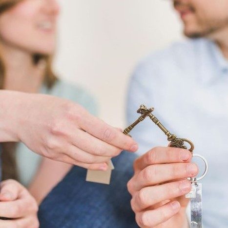 A couple holding keys to their house